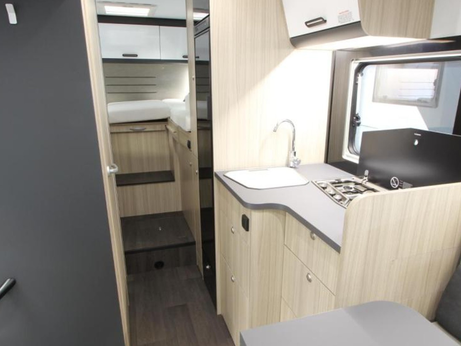 Leefruimte van de Sun Living S72DL camper met uitzicht op de dinette, keuken en bovenbed, in een moderne en lichte afwerking met slimme indeling.